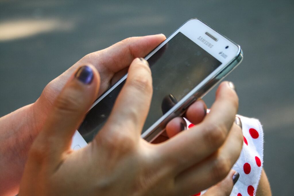 Mano sosteniendo un smartphone Android que puede aparecer como dispositivo no compatible en Play Store