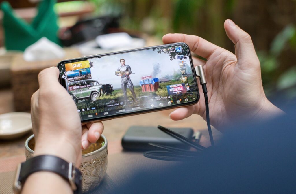 Persona jugando a un videojuego grande en el móvil, causa habitual del error 498 en Play Store