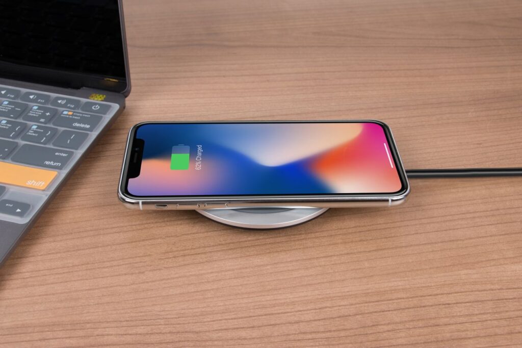 Primer plano de un iPhone cargando por la noche, en referencia a cómo la optimización de batería interrumpe las actualizaciones automáticas de Play Store y provoca el error 941