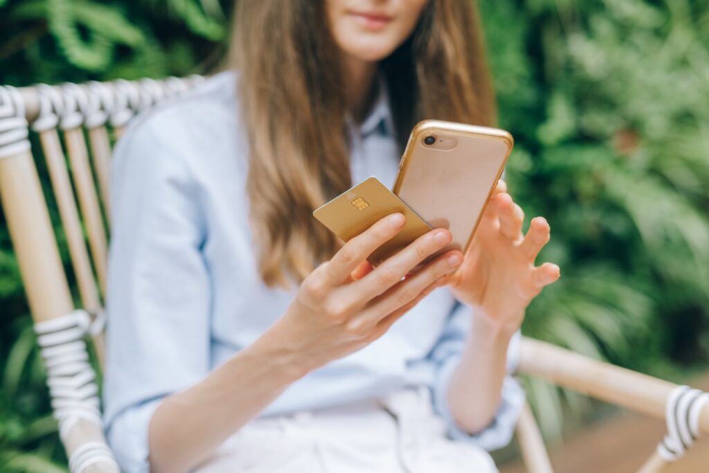 Persona usando el móvil con una tarjeta de crédito para pagar una compra en Play Store